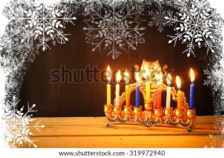 image of jewish holiday Hanukkah with menorah (traditional Candelabra). retro filtered image with  snowflakes overlay
