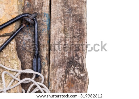 black boat anchor with rope on stone and old wooden board with white background