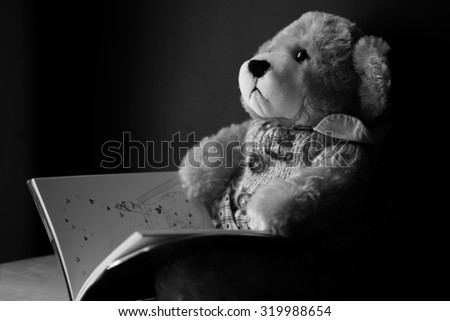 Teddy Bear toy alone on wooden floor vintage style.Black and White