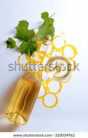 Wine goblet, bottle of wine and corks on picture painted with wine