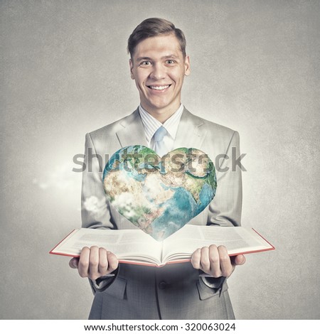 Young businessman with opened book in hands. Elements of this image are furnished by NASA