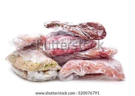 frozen raw meat, such as pork, chicken or beef, wrapped in plastic on a white background