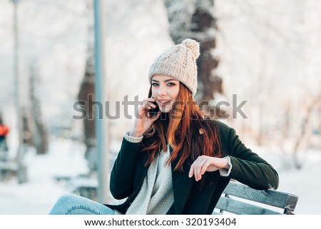 Young  woman smiling with smart phone and winter landscape 