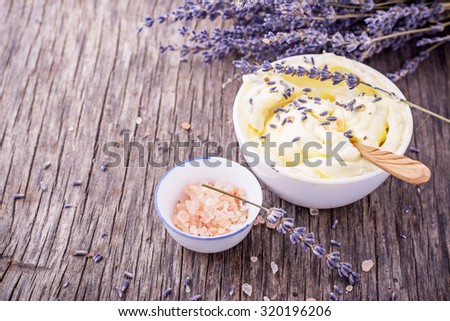 Herbal butter for breakfast with lavender flowers in a white ceramic cup with a wooden spoon on the wooden background with a bouquet of fragrant cut lavandly. selective Focus