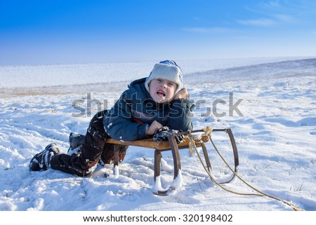 showing their emotions boy lying on sled