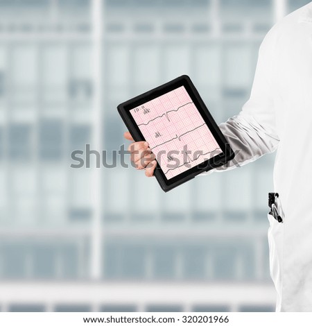 Doctor in a white coat, holding a digital tablet in his hand