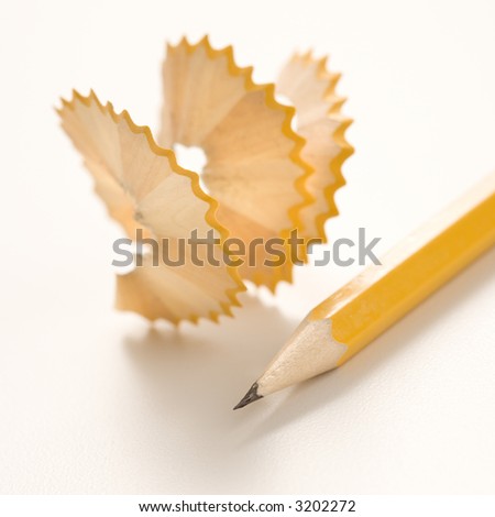 Sharp pencil next to spiral pencil shavings.