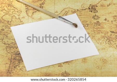 brush and paper on a old world map