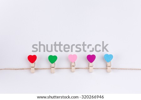 Colourful Love clothes pin hanging on the clothesline over white background