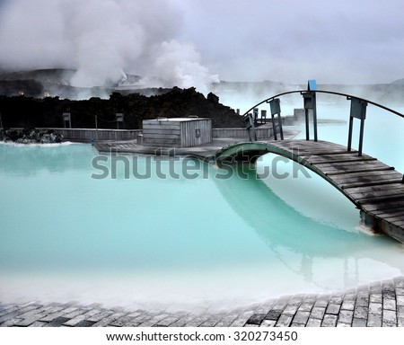 Blue lagoon, with its iconic bridge, revealing the stunning and tranquil beauty of its blue waters in Iceland, a natural wonder and tourist attraction Royalty-Free Stock Photo #320273450