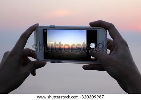 holding cellphone. taking picture