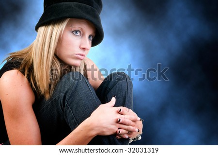 pretty woman sits looking into distance on blue background