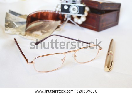 Vintage pen near  glasses on background with old picture