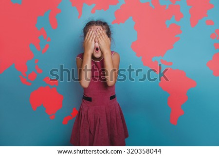 Teen girl covered her face with her hands against a background of world map geography science