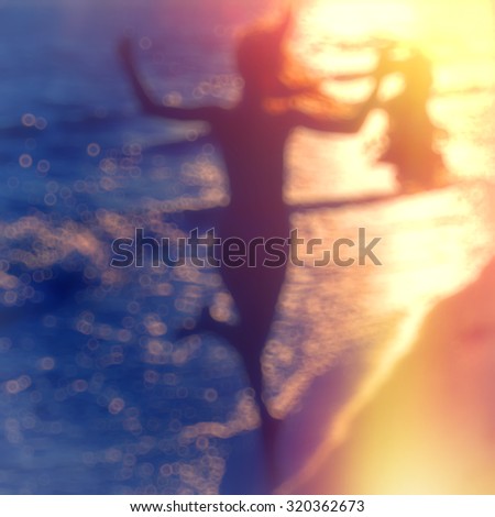 blurred background, a woman running along the beach in the setting sun