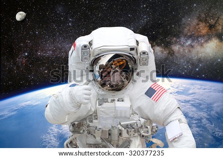 Astronaut on space mission with earth on the background. Elements of this image furnished by NASA.