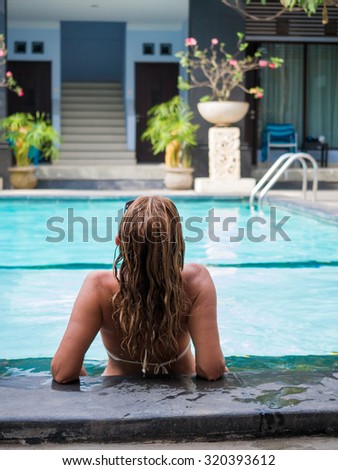 Womanl in the swimming pool at tropical resort in Asia