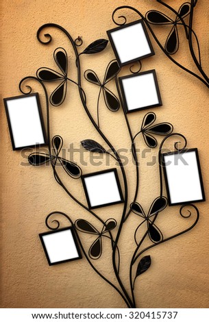 Curly iron picture holder with 6 empty frames leaning on a yellow wall