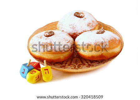 image of jewish holiday Hanukkah with donuts and wooden dreidels (spinning top). isolated on white
