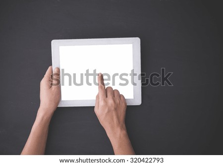 A portrait of Hand using a tablet pc, finger pressing imaginary option on blackboard background, mock up