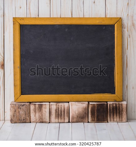 A portrait of a black chalkboard on wooden background, horizontally placed