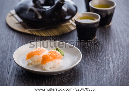 tea set and sushi on old wood background