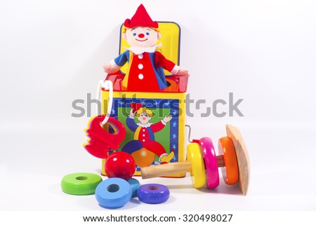 Jack-in-the-box toy and round wooden painted o-rings to stack for kids. Royalty-Free Stock Photo #320498027