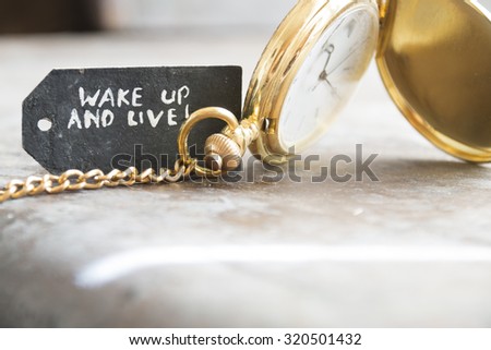 time idea, "wake up and live" idea, inscription on the label and gold pocket watch