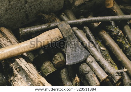 Axe and firewood on photo in vintage style color and selective focus