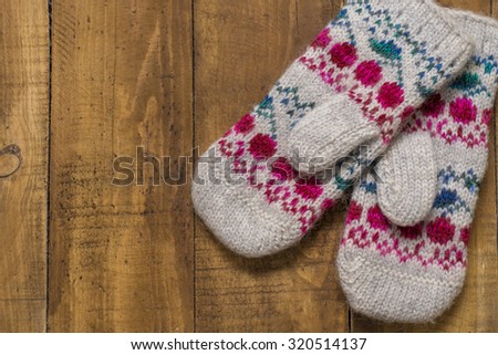 beautiful knitted mittens on a wooden background