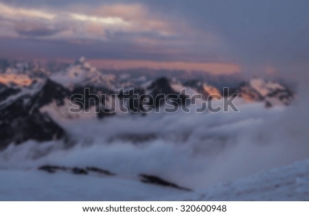 blurred background with snowy mountains. Beautiful winter panorama with snow covered trees blurred and filtered