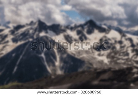 blurred background with snowy mountains. Beautiful winter panorama with snow covered trees blurred and filtered