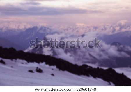 blurred background with snowy mountains. Beautiful winter panorama with snow covered mountains blurred and filtered