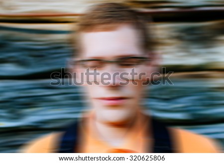 Abstract blurred defocused motion effect on young man with glasses