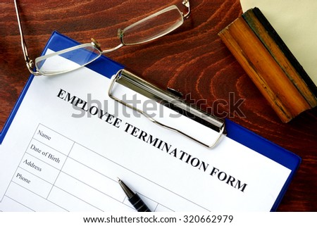Employee termination form on a wooden table. Royalty-Free Stock Photo #320662979