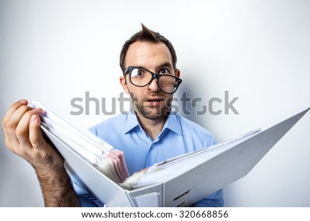 Funny photo of businessman with beard wearing shirt and glasses. Surprised businessman looking at camera with eyes wide open and holding folder full of documents. Isolated on white background