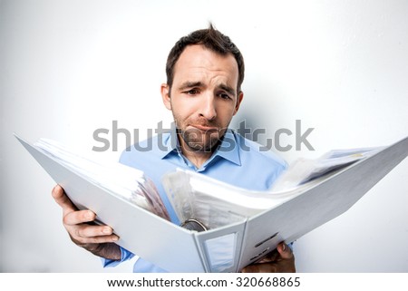 Funny photo of businessman with beard wearing shirt. Sad businessman looking at folder full of documents. Isolated on white background