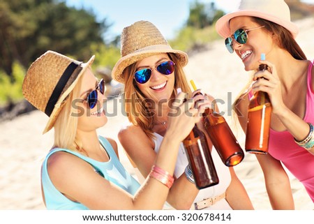 A picture of a group of friends drinking beer on the beach