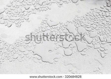 Metal with water drops, detail of a textured, wet steel