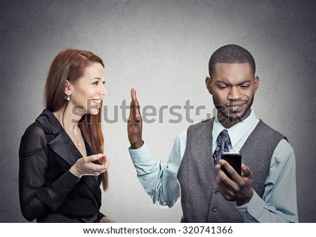 Attractive woman being ignored stopped by young handsome man looking at smartphone reading browsing internet isolated on gray wall background. Phone addiction concept. Human face expression emotions  Royalty-Free Stock Photo #320741366