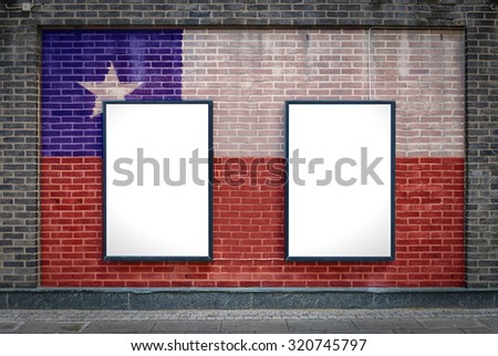 Two blank billboards attached to a buildings exterior brick wall which has a Chile flag painted on it.