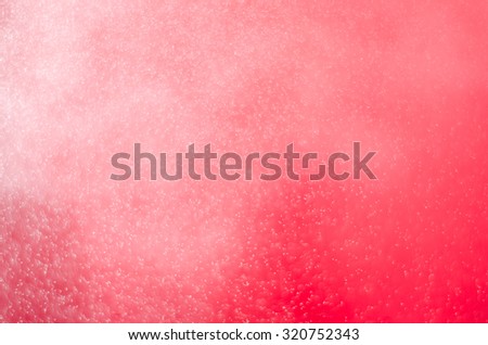 Water spray splashing on red color tone background.
