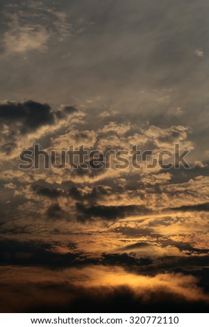 Beautiful landscape view of bright orange twilight and sky full of clouds with sunlight peeking through, horizontal picture