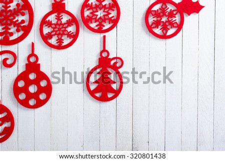 red felt Christmas ornaments on white wooden table background
