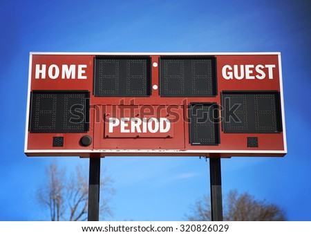 background of a scoreboard with home and guests written on it in front of a blue sky on a sunny summer day 