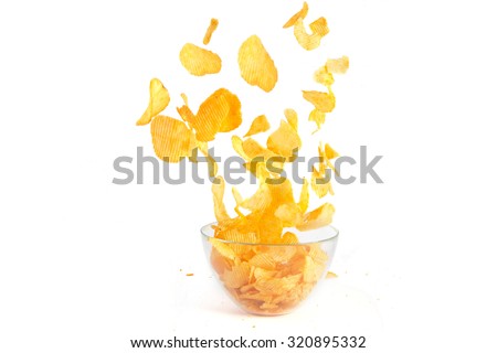 Flying over a bowl of potato crisps isolate on white background Royalty-Free Stock Photo #320895332