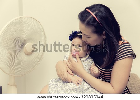 The little girl and mom was exposed electric fans because the heat, process color.