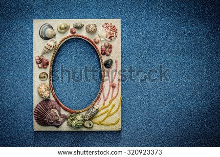 Picture frame made from sea shell on blue wall.