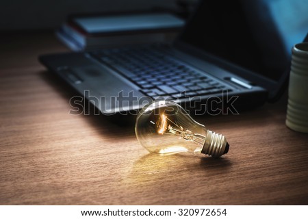 light bulb on wooden table with laptop