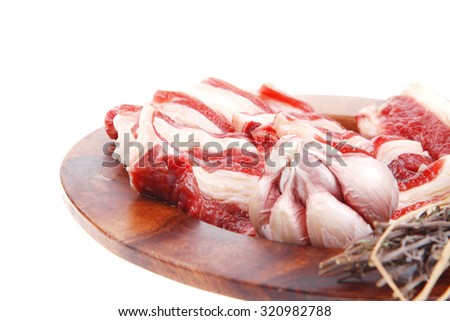 raw ribs with thyme and garlic on wooden isolated over white background